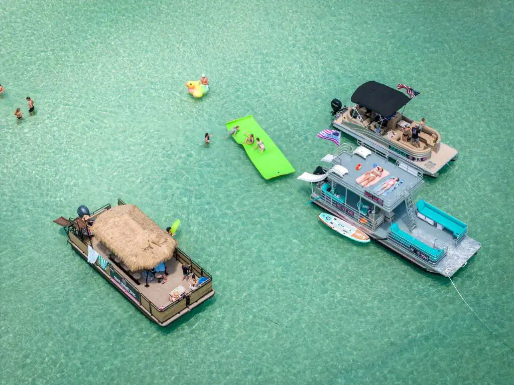 Colorful Key West boat rentals with floating platforms, water slides, and lounge areas for fun in the sun at the beach. Perfect for relaxing and exploring the ocean waters.