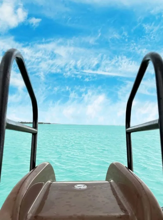 Kayak boarding ladder overlooking turquoise waters in Key West for boat rentals, ocean, seascape, relaxation, tropical destination, water activity, sunny weather, tourism, adventure, marine life.